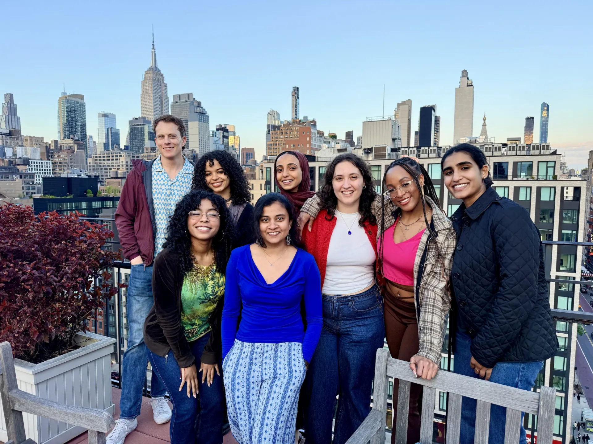 Eight people posing for a photo on a rooftop in Manhattan 